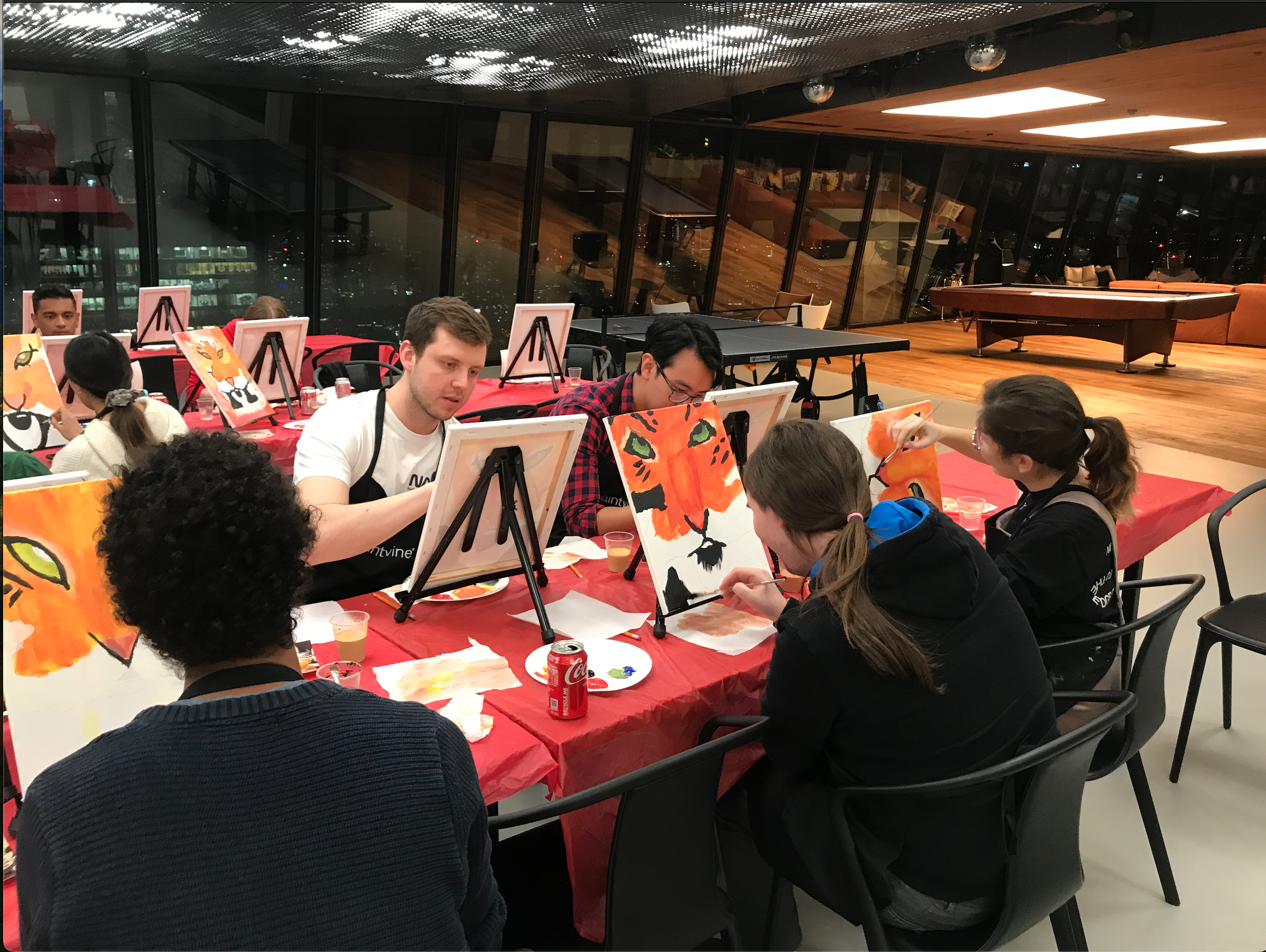 People in the breakout space painting on individual canvases