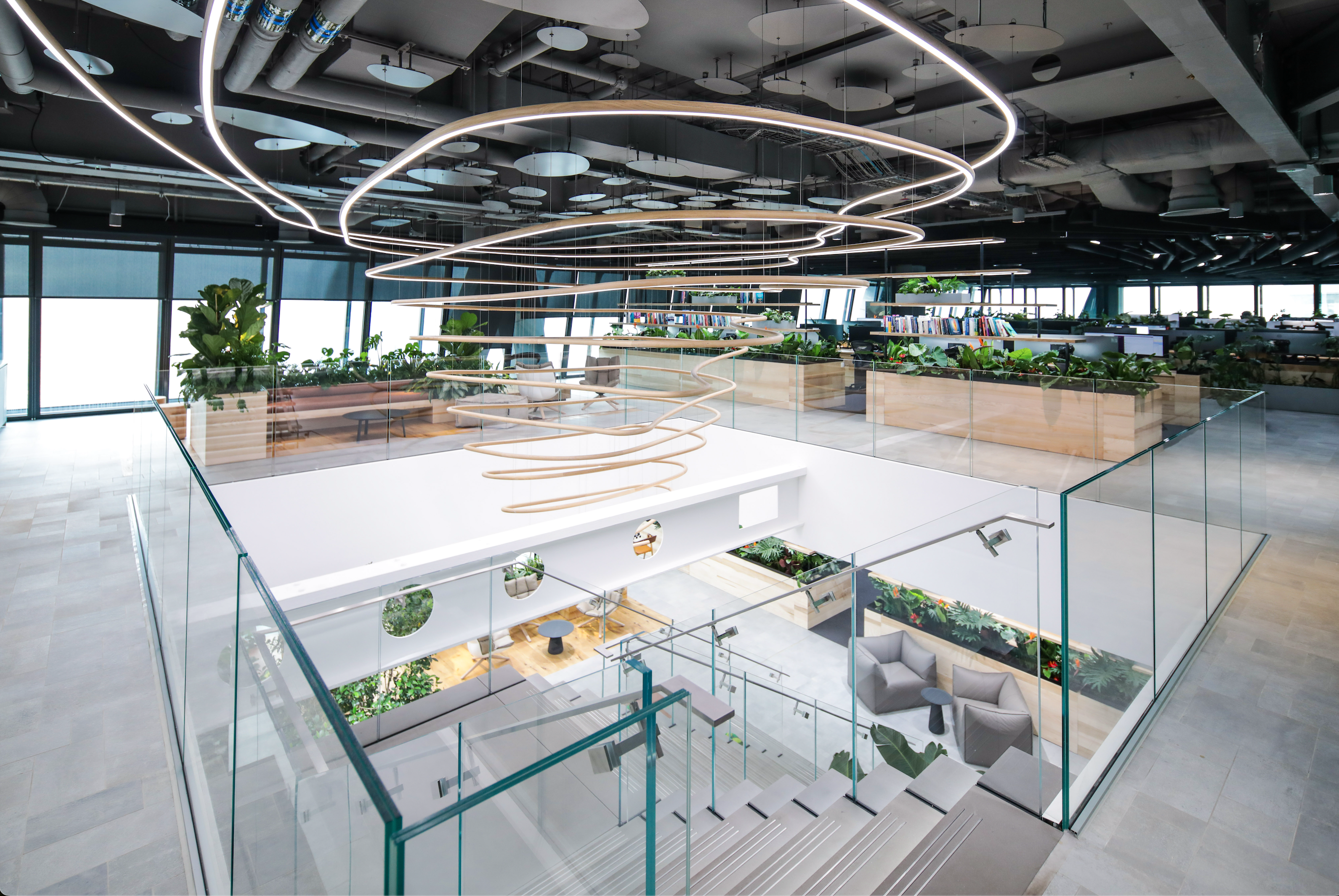 Office with lots of green plants and wooden standing desks