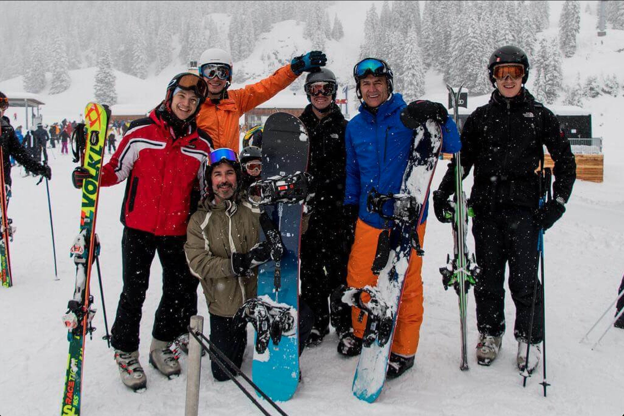 Seven Quadrature team employees laughing and smiling with snowboards